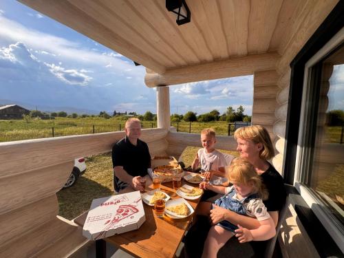 a family sitting at a table on the porch of a house at Mountain View in Vyshkove