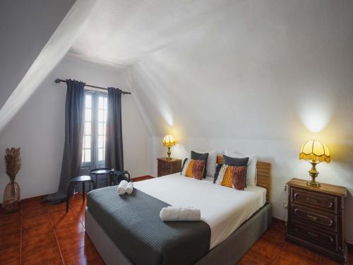 a bedroom with a large white bed and a window at Akisol Hostel Idanha in Idanha-a-Nova