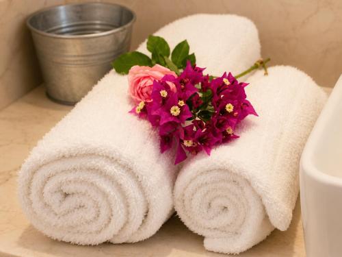a couple of towels with flowers on a bathroom counter at 9 Muses in Andros