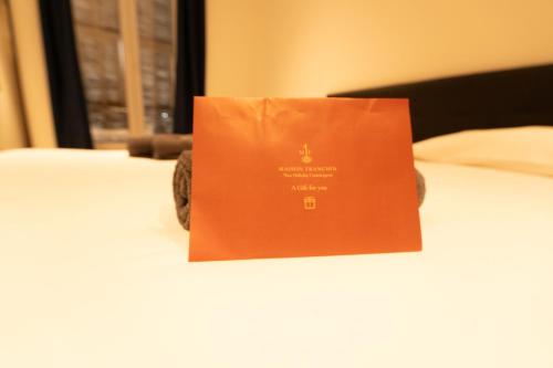 a paper bag sitting on top of a bed at Maison Rouget - Chambre 1 - Mimosa in Nice