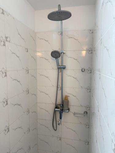 a shower with a shower head in a bathroom at Harmonie in Abidjan