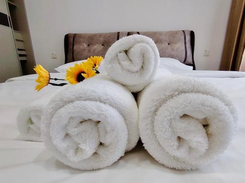 a pile of towels on a bed with flowers at Amberside Coastal Breeze Oasis in Johor Bahru