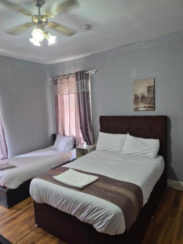 a bedroom with two beds and a ceiling at Prime Hotel in Middleton