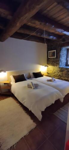 a large bedroom with two beds with white sheets at Cabaña Vento Norte in Vilamós