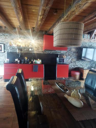 a kitchen with a wooden table and red cabinets at Cabaña Vento Norte in Vilamós