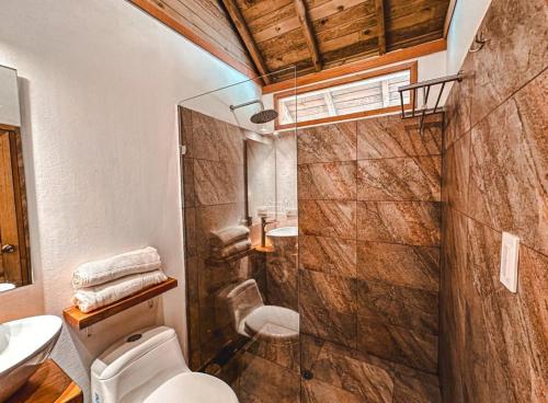 a bathroom with a shower and a toilet and a sink at REFUGIO el CAMPANO in Minca