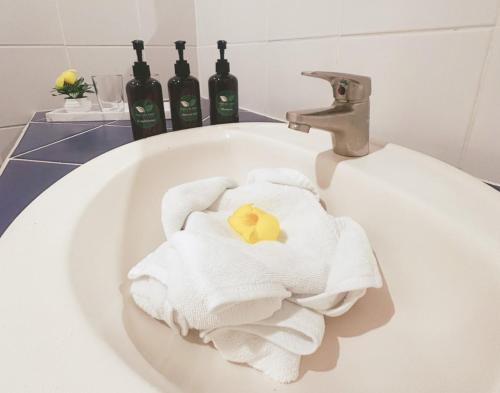 a white sink with towels and bottles of wine at Tabulia Tree Hotel and Villas in Manuel Antonio