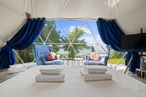 a room with two chairs and a table with a large window at Lake Glamp Mikołajki - Adults Only in Mikołajki