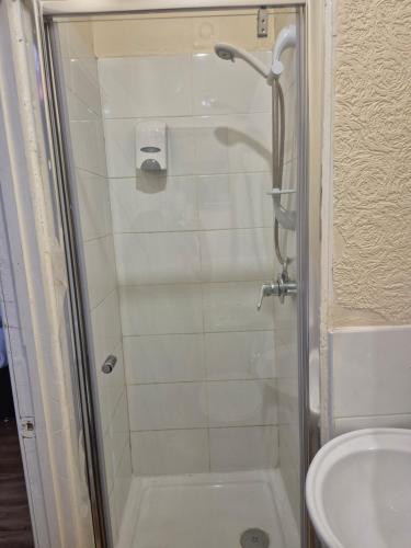 a bathroom with a shower and a toilet and a sink at Prime Hotel in Middleton