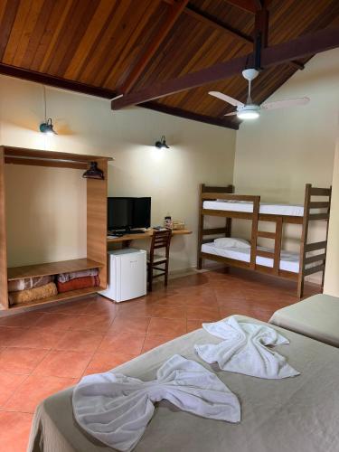 a bedroom with two bunk beds and a desk at Hotel fazenda Floresta do Lago in Socorro