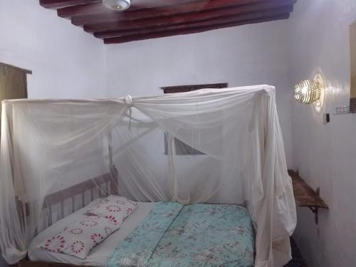 a bed with a canopy in a room at Beiytul Noor Apartment in Lamu