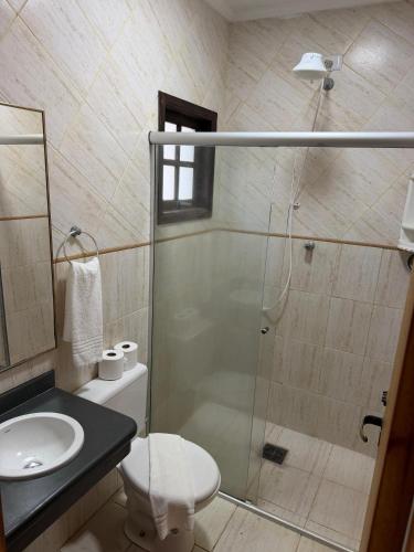 a bathroom with a shower and a toilet and a sink at Hotel fazenda Floresta do Lago in Socorro
