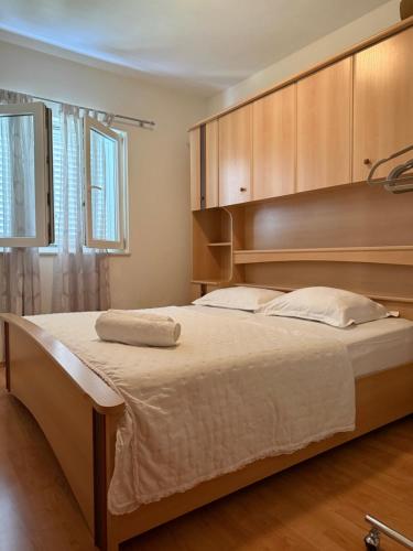 a bedroom with a large bed with wooden cabinets at Apartmani Petra i Igor in Makarska