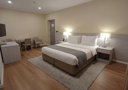 a bedroom with a large bed and a dining room at Mirador Hotel in Manama