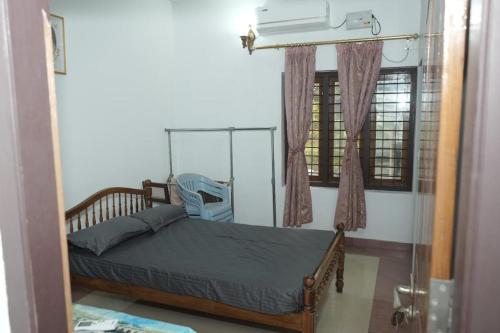 a bedroom with a bed and a window at VJ Riverfront Villa in Champakulam