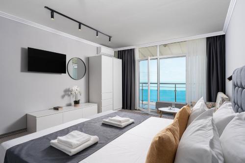 a living room with a couch and a large window at HOTEL ESKADA BEACH - Free Parking in Ahtopol