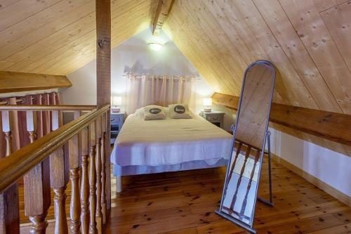 a bedroom with a bed in a wooden ceiling at Gîte avec jacuzzi La Halte de Chambord in Mur-de-Sologne