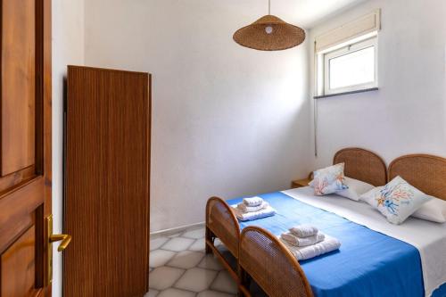 a bedroom with a bed with blue sheets and towels at Residence Parco Gioconda in Forio d'Ischia