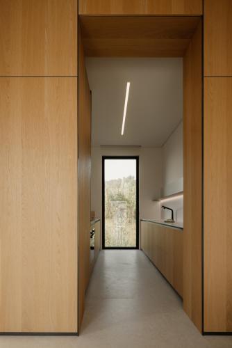 a hallway leading to a kitchen with a window at The Habitus Residence, a Design house in Corfu