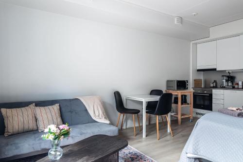 a living room with a blue couch and a kitchen at Modern Studio in Downtown Lahti in Lahti
