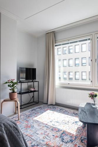 a living room with a large window and a television at Modern Studio in Downtown Lahti in Lahti