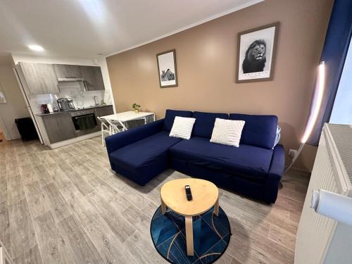 a living room with a blue couch and a table at Studio cosy au vieux centre in Cormeilles-en-Parisis