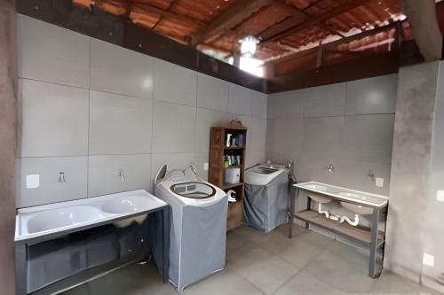 a bathroom with two sinks and a washing machine at Mini Privativa CA1 - Tiradentes / MG in Belo Horizonte