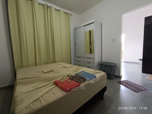 a bedroom with a bed with two bags on it at Mini Privativa CA1 - Tiradentes / MG in Belo Horizonte