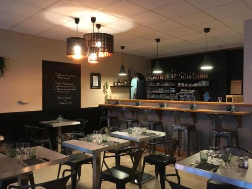 a restaurant with tables and chairs and a bar at Hotel du Centre - Restaurant le P'tit Gourmet in Tonnerre