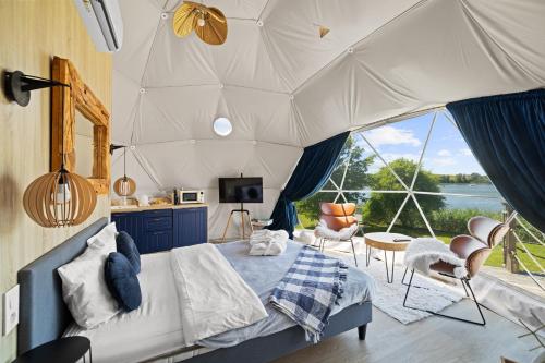 a bedroom with a tent with a view of the water at Lake Glamp Mikołajki - Adults Only in Mikołajki
