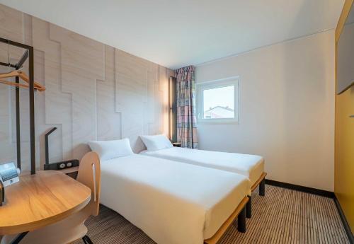 a hotel room with two beds and a table at B&B HOTEL Mâcon Sud 3 étoiles in Varennes-lès-Mâcon