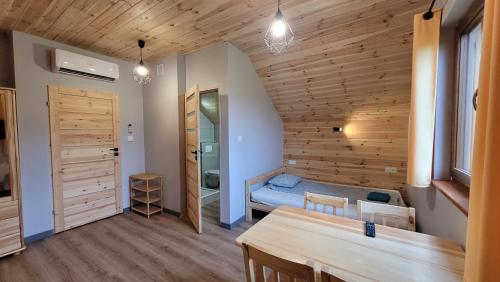 a small room with a bed and a table at Wrzosowe Wzgórze Domki 3 sypialnie in Chęciny