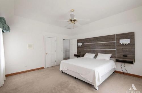 a bedroom with a white bed and a ceiling fan at AEQ Luxury House 1 in Orland Park
