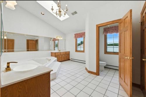 a bathroom with a tub and a sink and a toilet at AEQ Luxury House 1 in Orland Park