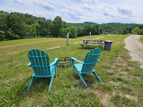 two blue chairs and a picnic table in a field at Hocking Hills Store Campsite #4 in Logan