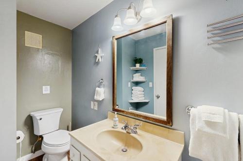 a bathroom with a sink and a mirror and a toilet at Rockaway Beach View in Port Blakely