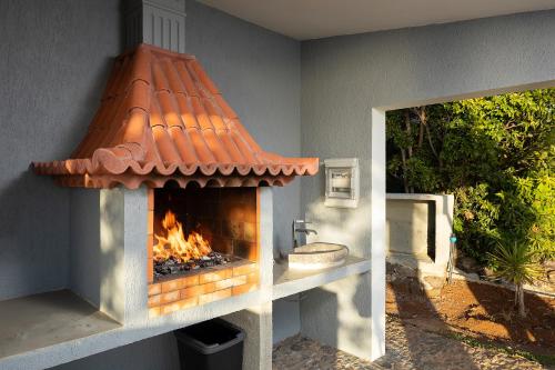 a outdoor fireplace with a sink and a fire place at Massapez Royals in Fajã da Ovelha