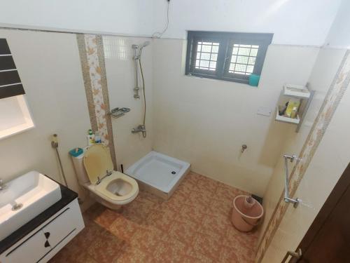 a bathroom with a toilet and a shower and a sink at VJ Riverfront Villa in Champakulam