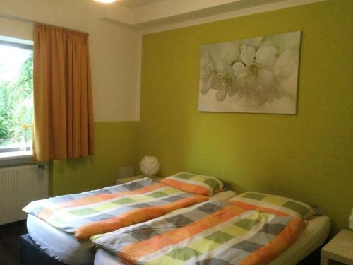 two beds in a bedroom with green walls at Villa Boskoop in Stryck