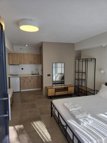 a bedroom with a large bed and a kitchen at Amaryllis Luxury Living in Nea Vrasna
