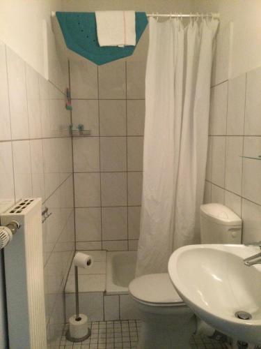 a white bathroom with a toilet and a sink at Villa Boskoop in Stryck