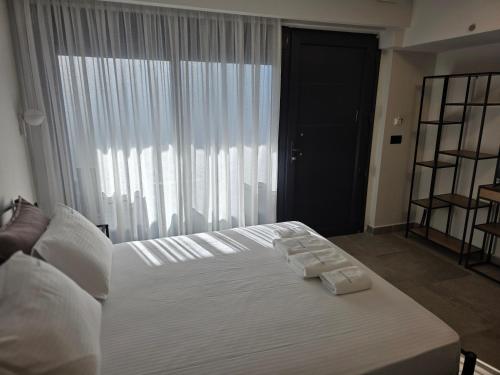 a bedroom with a white bed with towels on it at Amaryllis Luxury Living in Nea Vrasna