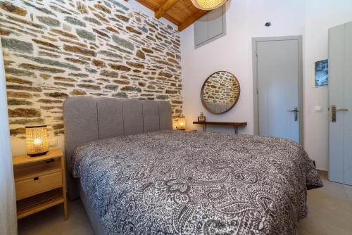 a bedroom with a bed and a stone wall at Orange House - Upper West apartment in Promírion