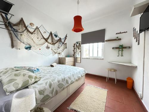 a bedroom with a bed and a flat screen tv at Fonte da Telha Beach Hostel in Costa da Caparica