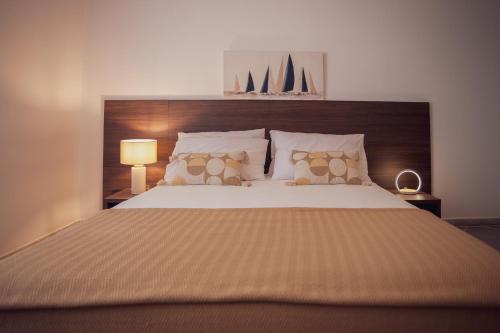 a bedroom with a large bed with a wooden headboard at Villa IV - PRIVATE LIVING in Alghero