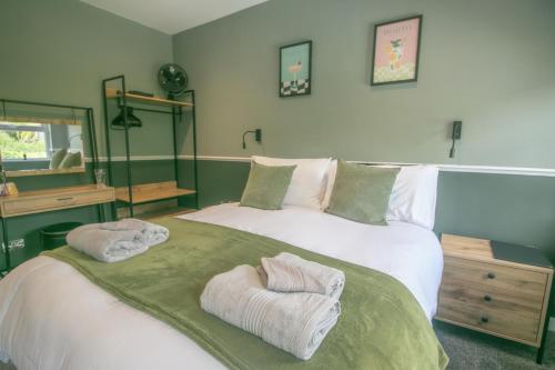 a bedroom with a large bed with towels on it at Bronte Breaks in Haworth