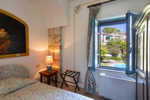 a bedroom with a bed and a window with a tub at B&B Villa Clodia in Saturnia