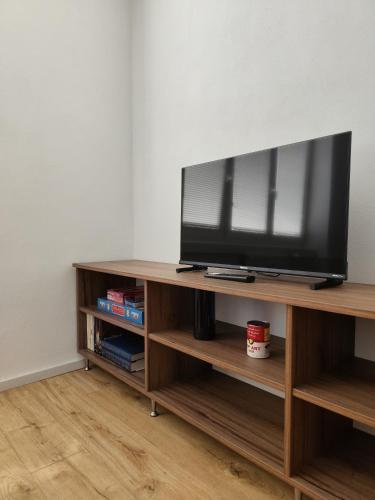 a flat screen tv sitting on top of a wooden entertainment center at Studio11 in Medzilaborce