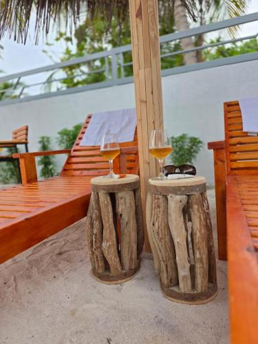two glasses of wine sitting on top of logs at Ee Seaview Maldives in Vevaru