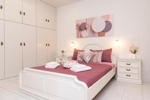a white bedroom with a large bed with white cabinets at La Casa Seni Near Athens Airport in Papangeláki